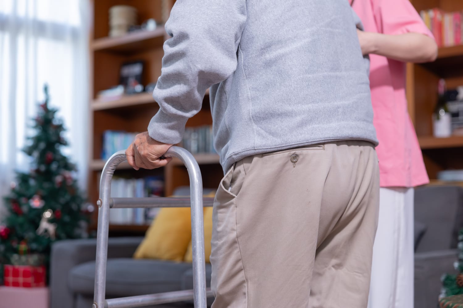 Angehörige hilft einer Seniorin mit dem Rollator